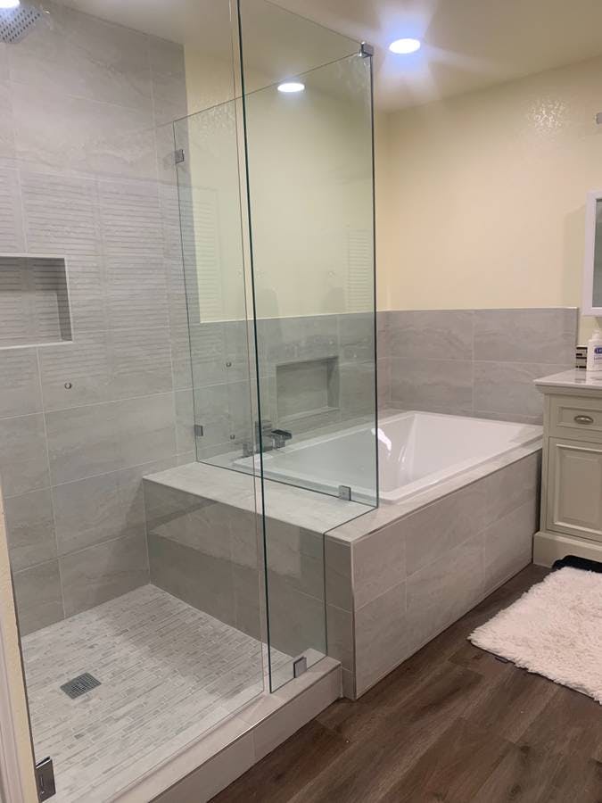 remodeled bathroom with new luxury bathtub and laminate flooring