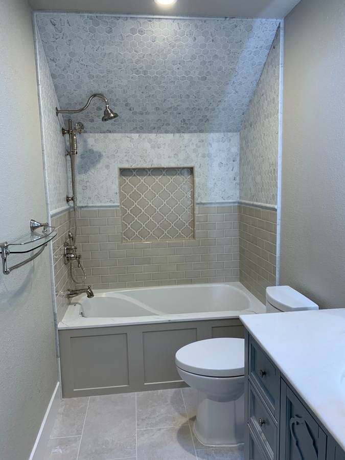 newly remodeled bathroom with bathtub and custom tile backsplash