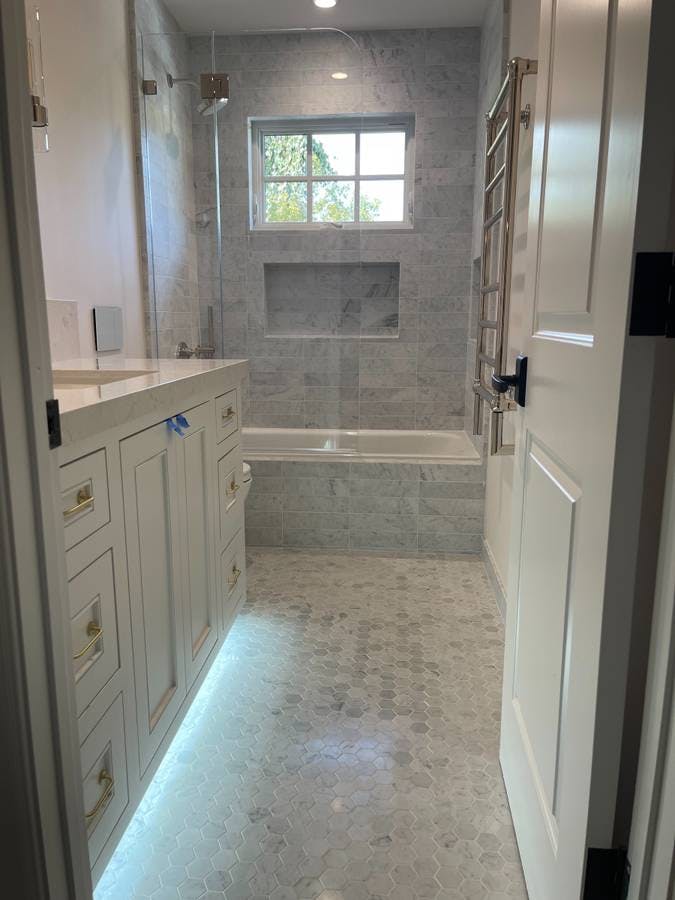 newly remodeled bathroom with custom blue variation of tile flooring and shower tile backsplash